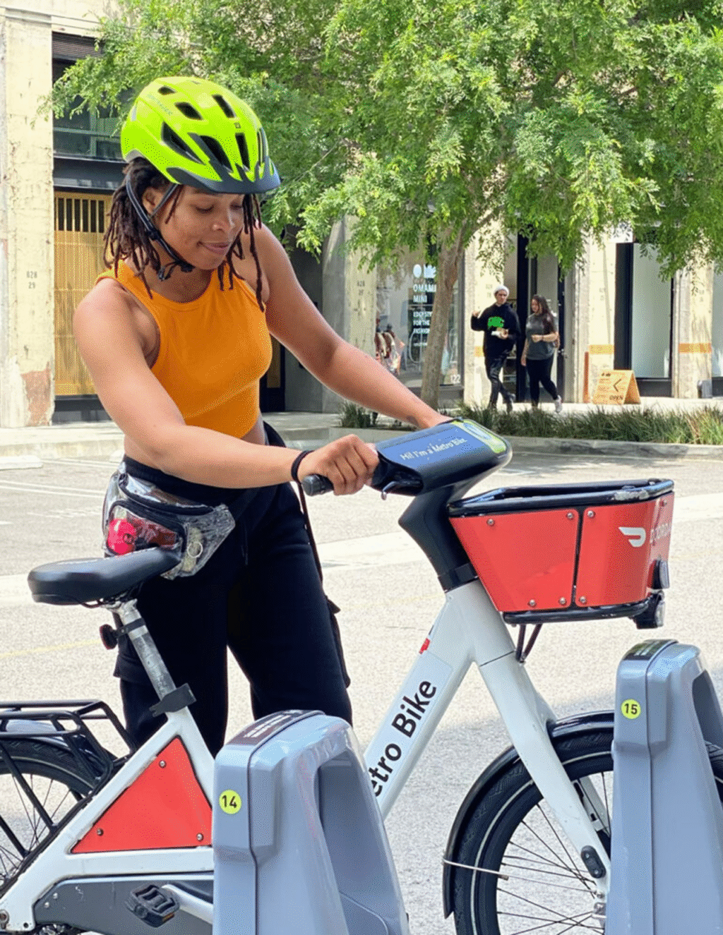 A person in a helmet docks a bike at a Los Angeles Metro bike share station.