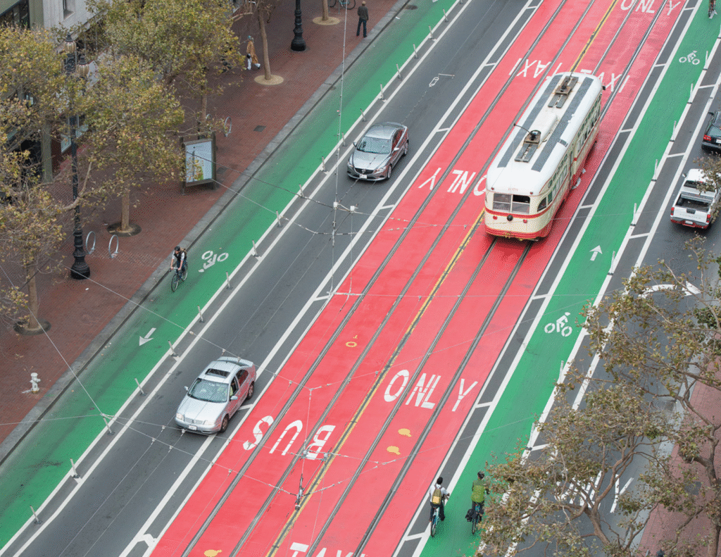 An overhead view of center-running red-painted bus lanes and green-painted bike lanes on San Francisco's Market Street.