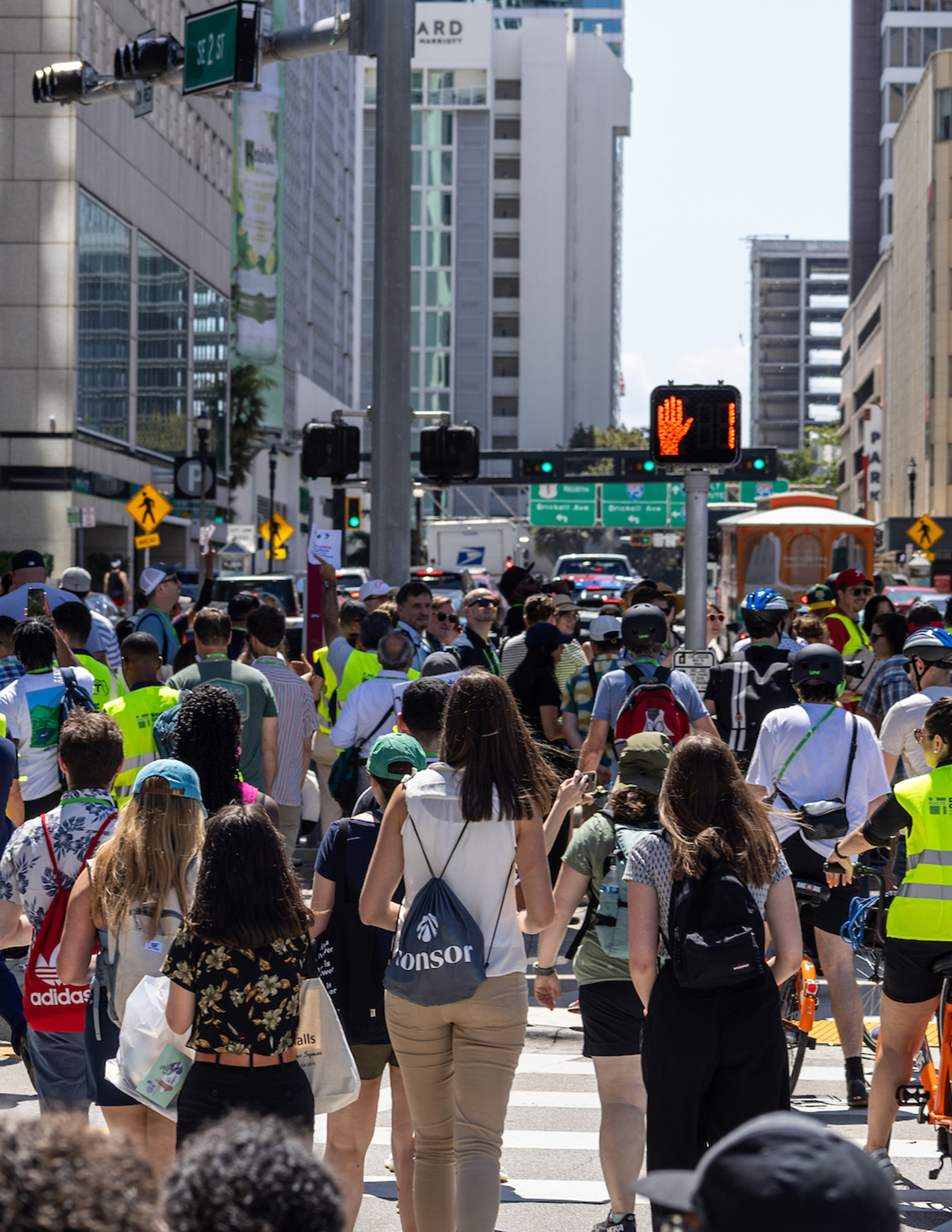 Large group of people walking and on bikes crossing the street to start walkshops at the Designing Cities Conference in Miami.