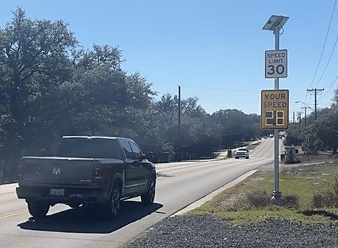 A radar feedback sign sign indicates that a pick-up truck is traveling at 28 miles per hour. The posted speed limit is 30 miles per hour.