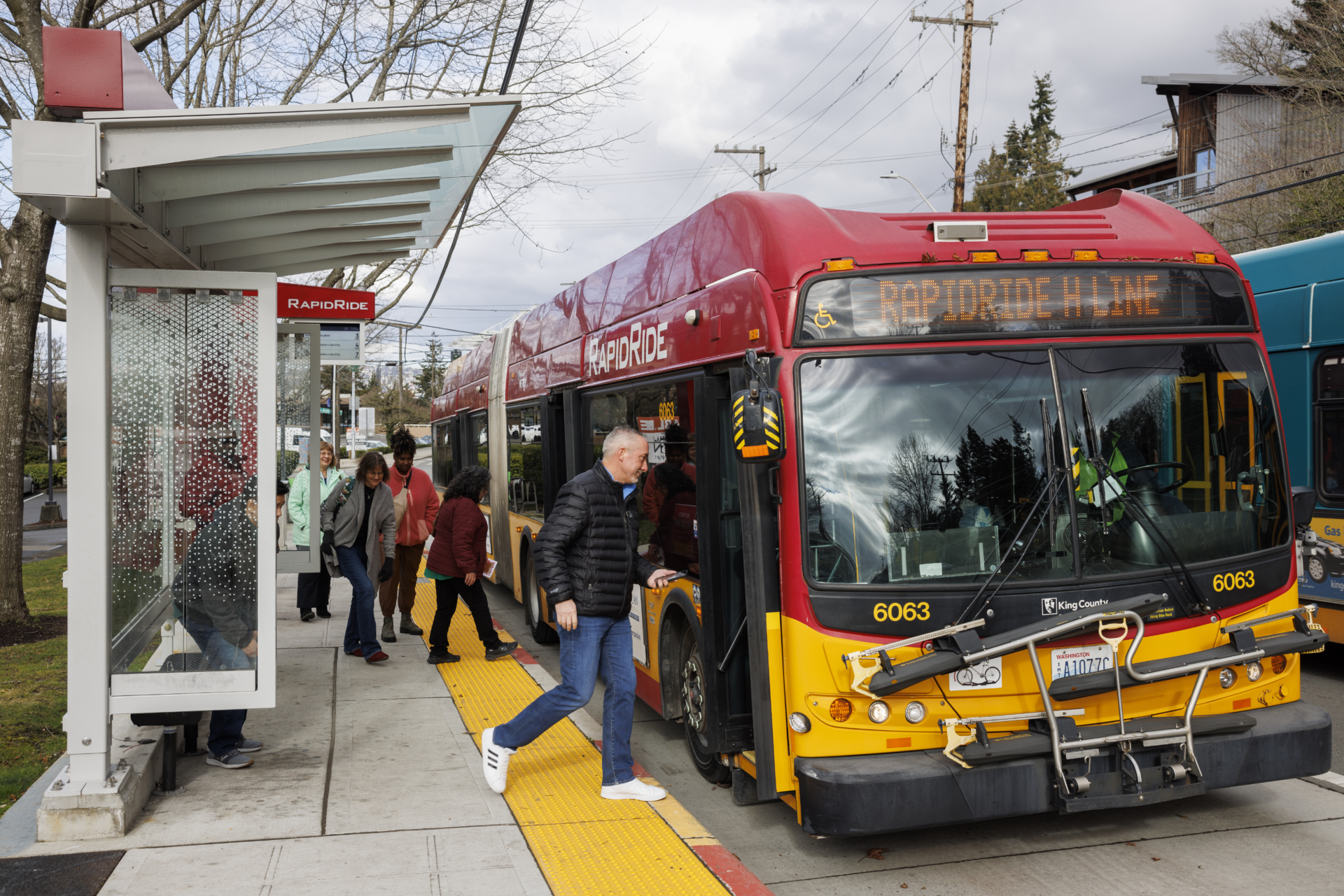 Multiple people board a King County Rapid Ride bus.